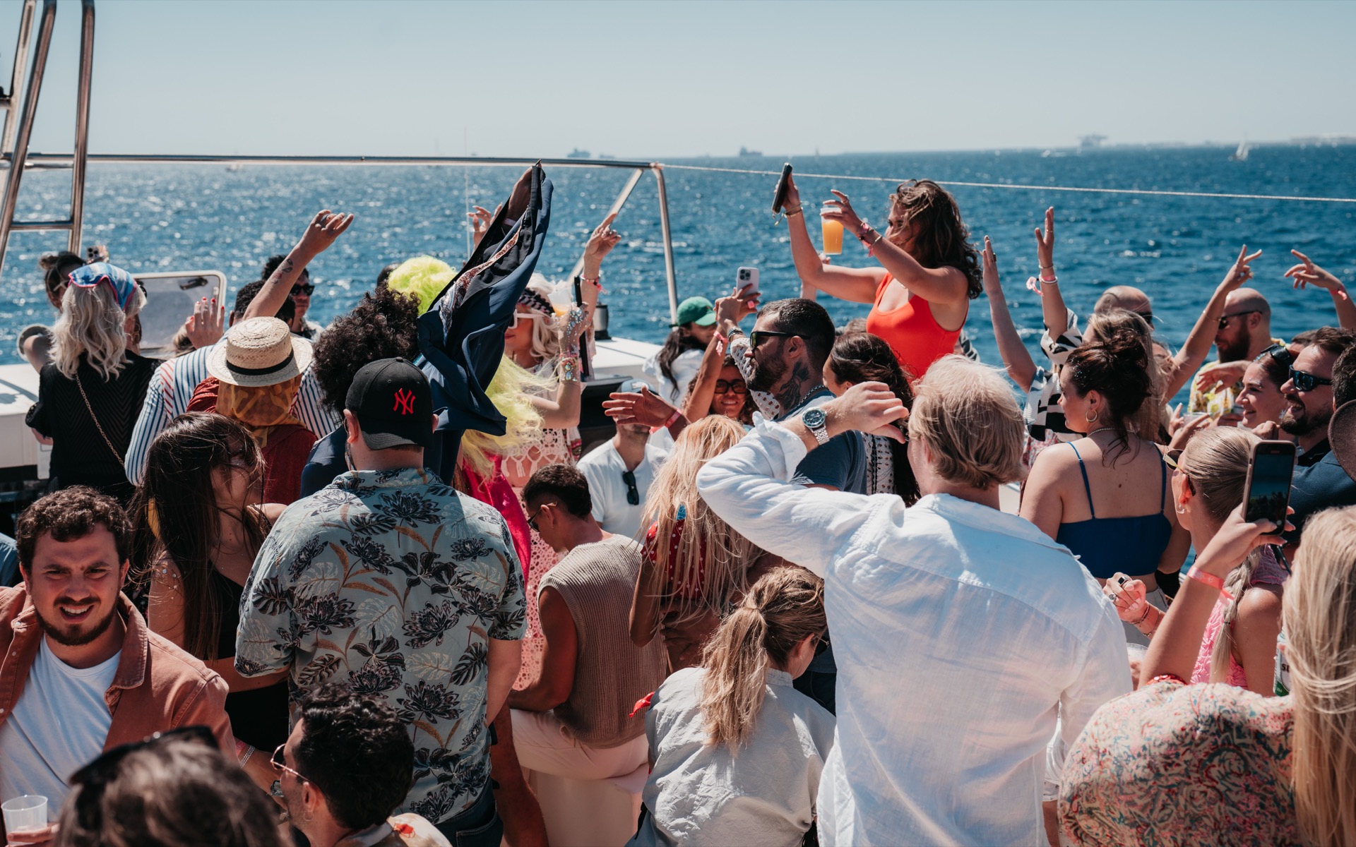Luxury catamaran boat party in Barcelona at sunset, energetic crowd, Mediterranean sea, golden hour lighting